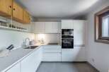 This modern kitchen boasts sleek, minimalist design with clean lines and ample storage.