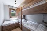 This cozy bedroom features custom-built bunk beds and a twin bed, perfect for a family or group.
