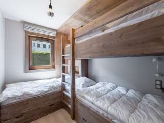 This cozy bedroom features custom-built bunk beds and a twin bed, perfect for a family or group.