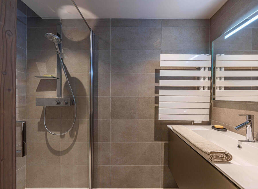Step into a modern bathroom oasis! This stylish space features a sleek shower with a glass enclosure, perfect for a refreshing start to your day.