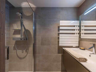 Step into a modern bathroom oasis! This stylish space features a sleek shower with a glass enclosure, perfect for a refreshing start to your day.
