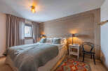 This cozy bedroom features a rustic wooden accent wall, creating a warm and inviting atmosphere.
