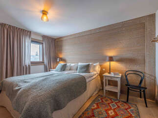 This cozy bedroom features a rustic wooden accent wall, creating a warm and inviting atmosphere.