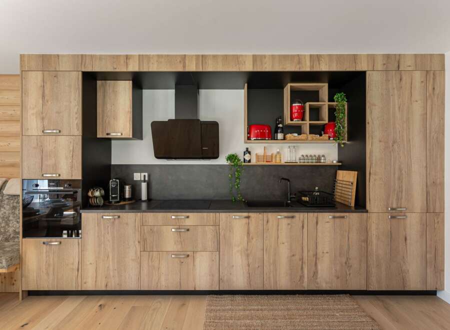 This modern kitchen boasts sleek wooden cabinetry, offering ample storage and a warm, inviting atmosphere.