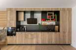 This modern kitchen boasts sleek wooden cabinetry, offering ample storage and a warm, inviting atmosphere.