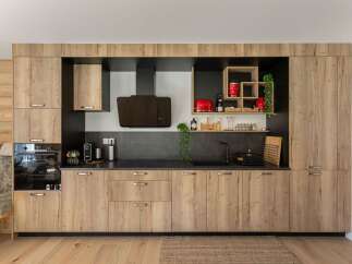 This modern kitchen boasts sleek wooden cabinetry, offering ample storage and a warm, inviting atmosphere.