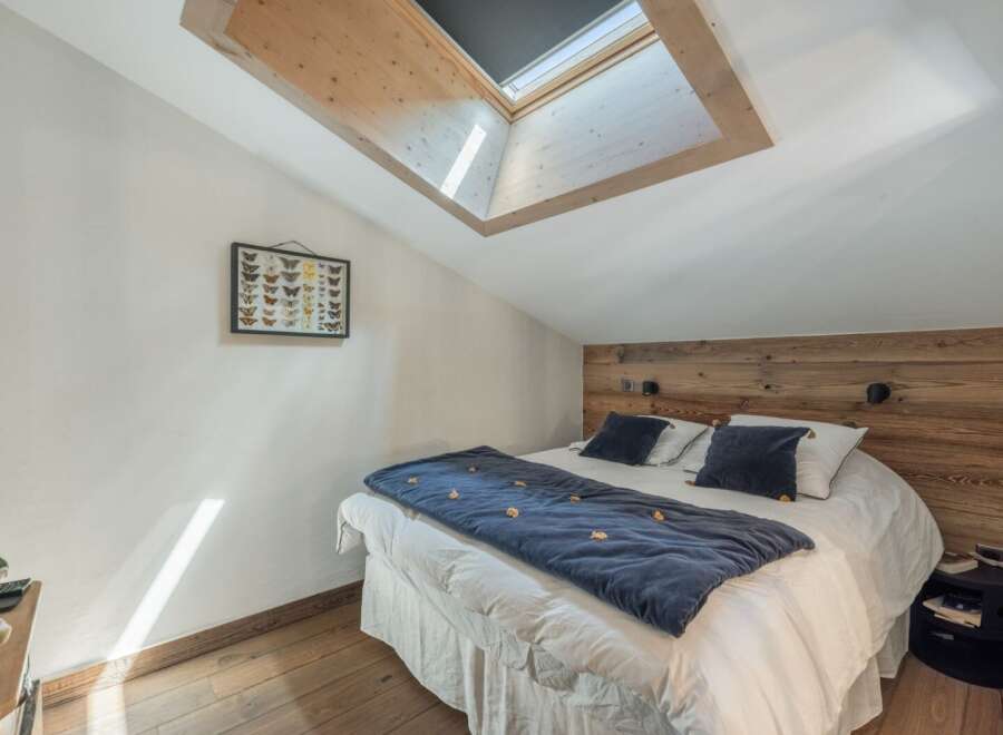 This cozy bedroom features a unique skylight, allowing natural light to flood the space.