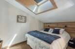 This cozy bedroom features a unique skylight, allowing natural light to flood the space.