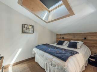 This cozy bedroom features a unique skylight, allowing natural light to flood the space.