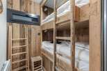 This cozy bedroom features custom-built wooden bunk beds, perfect for accommodating guests or family members.
