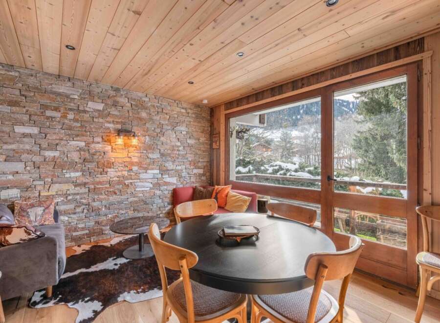 Experience the charm of this stunning property, featuring a cozy dining area with a round table and comfortable chairs.