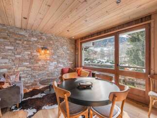 Experience the charm of this stunning property, featuring a cozy dining area with a round table and comfortable chairs.