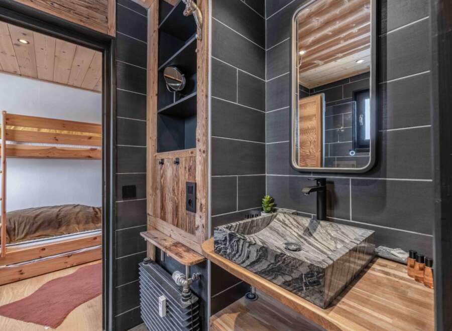 This stunning bathroom features a unique stone sink and a sleek black faucet, creating a modern yet rustic ambiance.