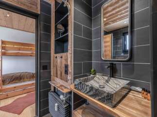 This stunning bathroom features a unique stone sink and a sleek black faucet, creating a modern yet rustic ambiance.