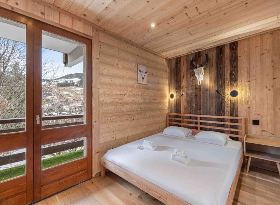 Experience rustic charm in this cozy bedroom, featuring stunning wooden paneling and a comfortable bed.