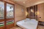 Experience rustic charm in this cozy bedroom, featuring stunning wooden paneling and a comfortable bed.