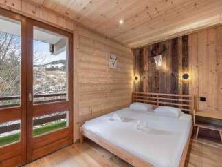Experience rustic charm in this cozy bedroom, featuring stunning wooden paneling and a comfortable bed.
