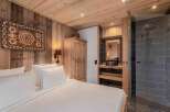 Experience rustic luxury in this stunning bedroom featuring a cozy wooden interior and a modern bathroom.