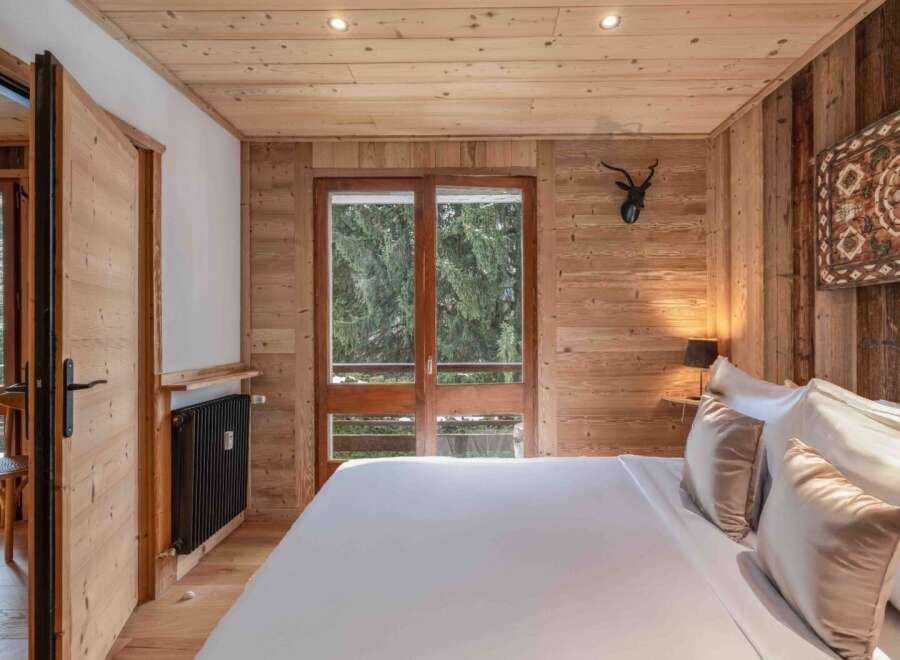 Experience the warmth and charm of this inviting bedroom, featuring exquisite wood paneling that creates a cozy ambiance.