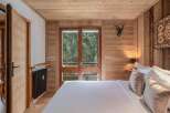 Experience the warmth and charm of this inviting bedroom, featuring exquisite wood paneling that creates a cozy ambiance.