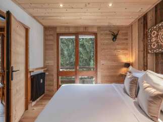 Experience the warmth and charm of this inviting bedroom, featuring exquisite wood paneling that creates a cozy ambiance.