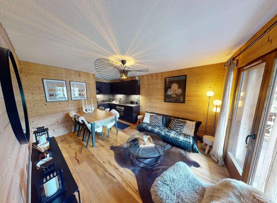 Discover the charm of this stunning property, featuring a cozy living space with wooden accents and a modern kitchen.