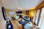 Discover the charm of this stunning property, featuring a cozy living space with wooden accents and a modern kitchen.