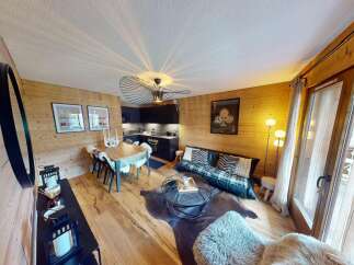 Discover the charm of this stunning property, featuring a cozy living space with wooden accents and a modern kitchen.
