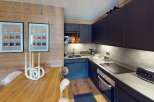 This modern kitchen features sleek black cabinetry, a stylish countertop, and a built-in oven.