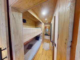 Step into this cozy cabin retreat, featuring a charming bunk bed setup perfect for family or friends.