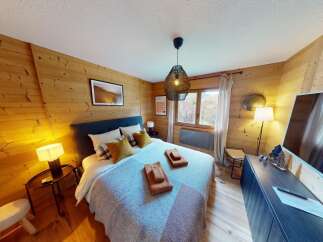 Experience the warmth and charm of this cozy bedroom, featuring stunning wood paneling that adds a touch of rustic elegance.