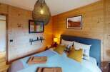 This cozy bedroom features a rustic wooden wall design, creating a warm and inviting atmosphere.