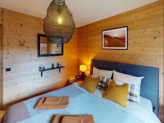 This cozy bedroom features a rustic wooden wall design, creating a warm and inviting atmosphere.