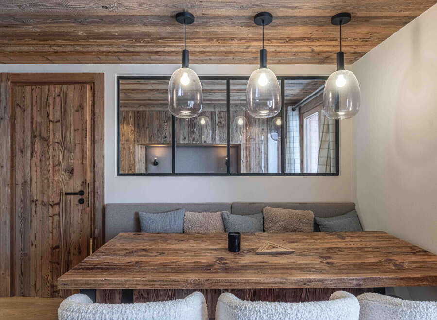 This stunning dining area showcases rustic charm with its wooden table and ceiling beams.