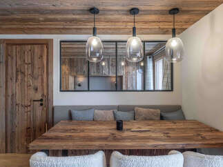 This stunning dining area showcases rustic charm with its wooden table and ceiling beams.