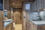 This stunning kitchen showcases rustic charm with its warm wooden paneling and sleek countertops.