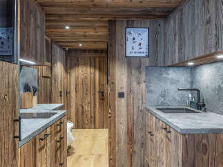 This stunning kitchen showcases rustic charm with its warm wooden paneling and sleek countertops.