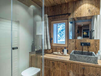 This stunning bathroom showcases rustic charm with its wooden accents and a modern touch.