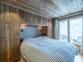 This cozy bedroom features a rustic wooden design, creating a warm and inviting atmosphere.