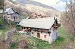 Discover the charm of this stunning mountain property, featuring a rustic stone facade and a modern metal roof.