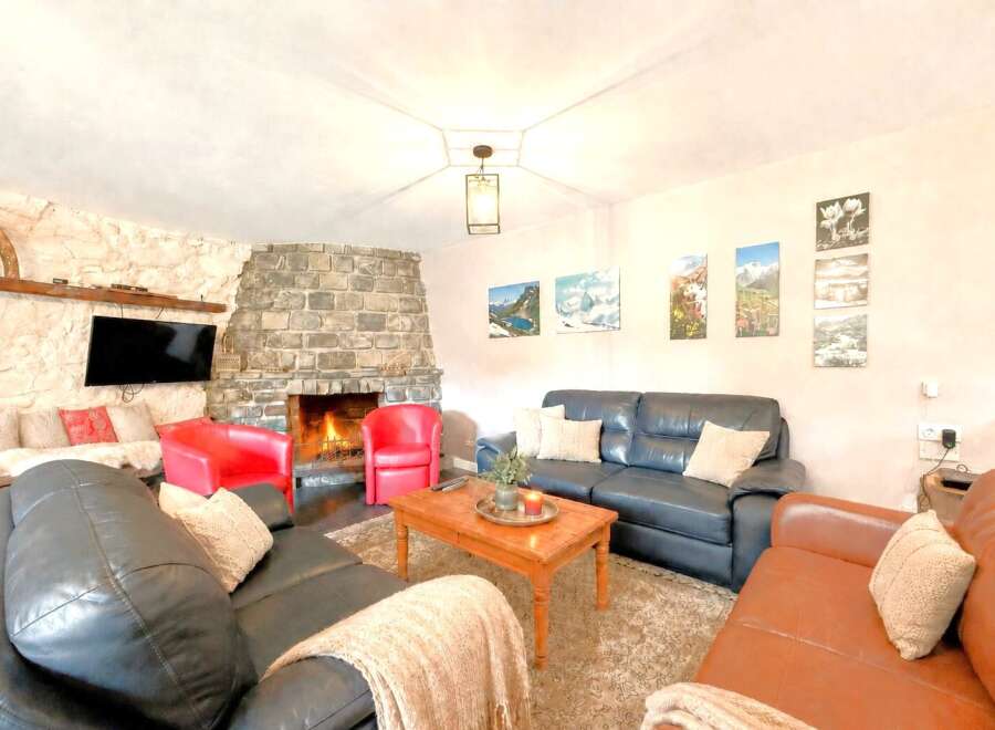 Cozy up in this stunning living room featuring a beautiful stone fireplace, perfect for those chilly evenings.