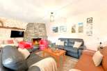Cozy up in this stunning living room featuring a beautiful stone fireplace, perfect for those chilly evenings.