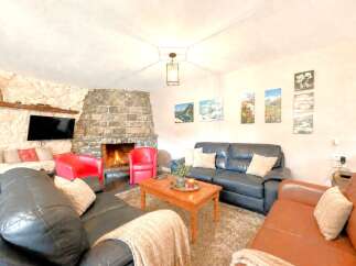 Cozy up in this stunning living room featuring a beautiful stone fireplace, perfect for those chilly evenings.