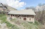 Discover a charming stone house nestled in a picturesque mountain setting.