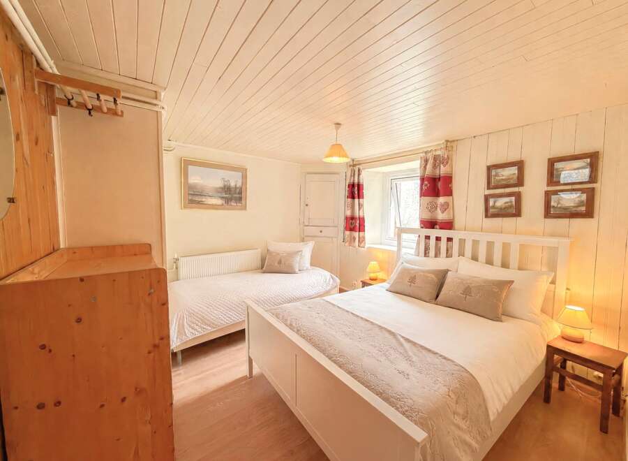 This charming bedroom offers a cozy and inviting atmosphere, perfect for a relaxing retreat.