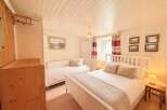 This charming bedroom offers a cozy and inviting atmosphere, perfect for a relaxing retreat.