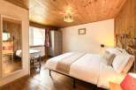 This cozy bedroom features a warm wooden ceiling and flooring, creating a rustic and inviting atmosphere.