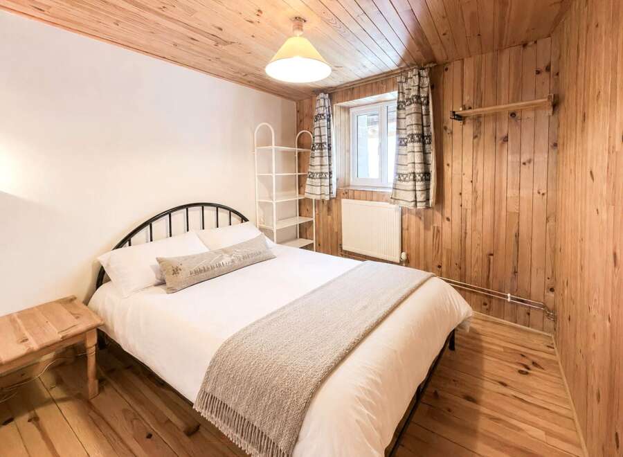 This cozy bedroom features a rustic wooden interior, creating a warm and inviting atmosphere.