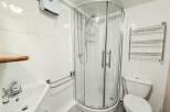 This well-maintained bathroom features a modern shower enclosure, perfect for a refreshing start to your day.