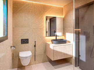 This modern bathroom features a sleek design with geometric patterned walls and a floating vanity.
